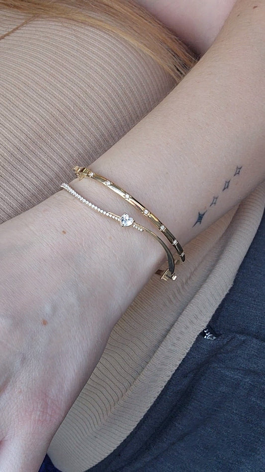 Wavy diamond bangles in gold stacked on the wrist, handmade by Margaret Krinetz