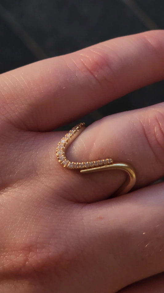 Wavy gold ring with pavé diamonds worn on the finger, a symbol of freedom for New York women